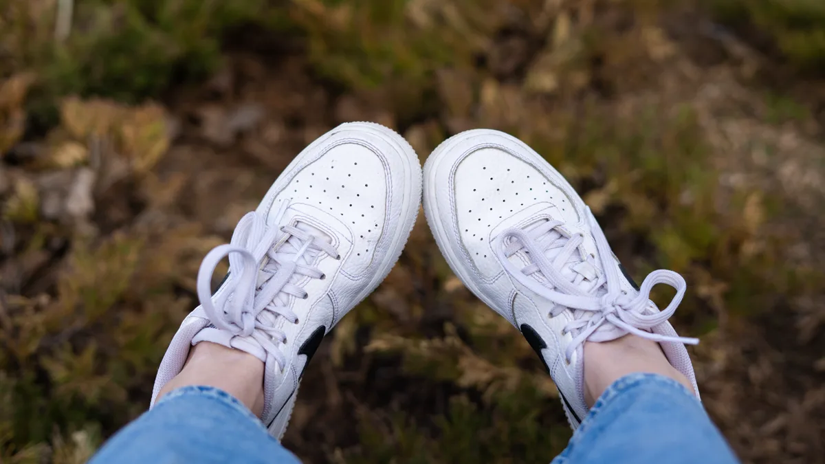 Comfortable white sneakers with cushioned rubber soles Comfortable flat white sneakers with thick rubber soles suitable for standing hours on stadium concrete