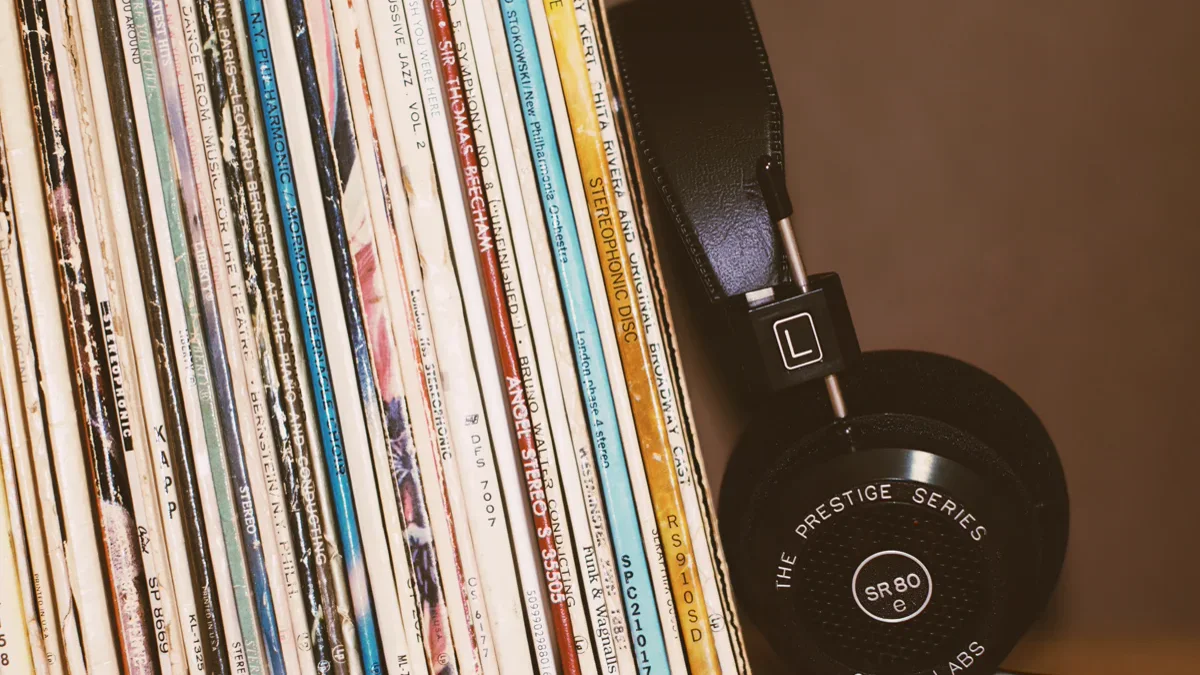 High-fidelity audio headphones resting on an open vinyl album sleeve on a wooden desk