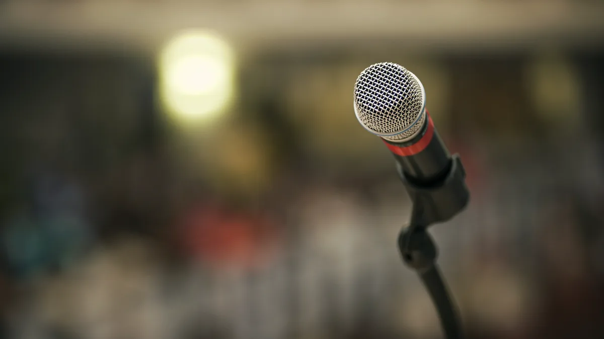 Vintage stage microphone on a stand against a concert lighting backdrop for music costumes