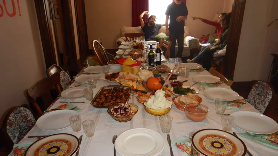 Thanksgiving dinner table spread with plates and festive holiday food for family viewing