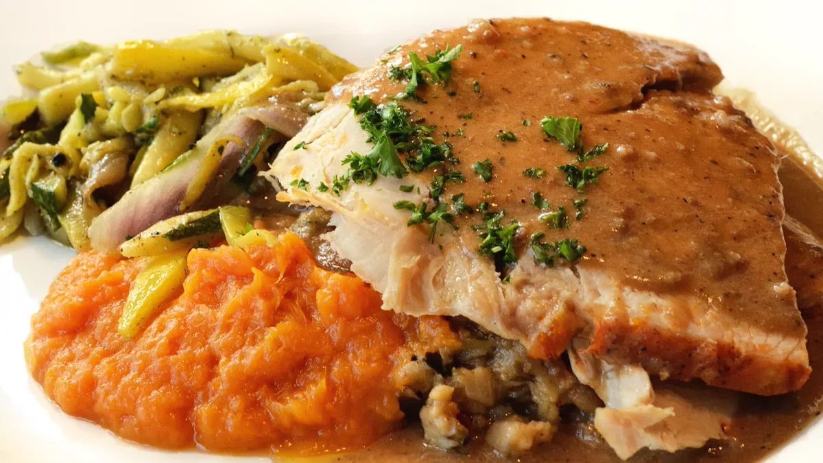 Golden roasted Thanksgiving turkey served on a platter surrounded by autumn garnish